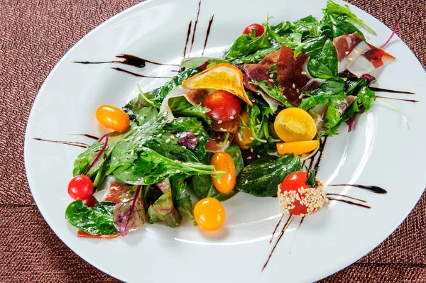 Grønn salat toppet med gule tomater . – stockfoto