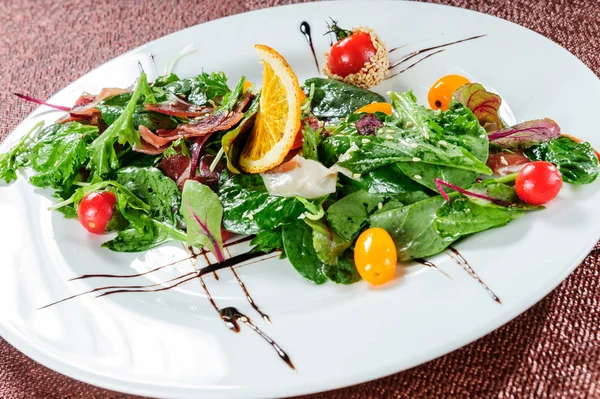 Groene salade, gegarneerd met gele tomaten. — Stockfoto