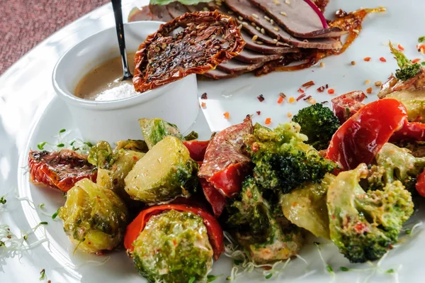 Cerdo al horno en rodajas con brócoli al vapor, zanahoria, coles de Bruselas y calabacín . —  Fotos de Stock