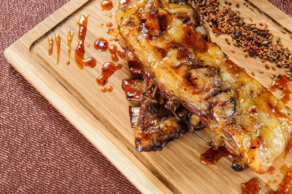 Filete de carne de cerdo a la parrilla en placa de corte de madera sobre mesa de madera . —  Fotos de Stock