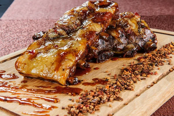Grillad fläsk kött biff på trä skär plattan över träbord. — Stockfoto