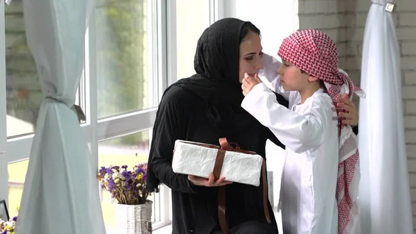 Arabische Mutter und Sohn posieren mit Geschenk indoor. — Stockfoto