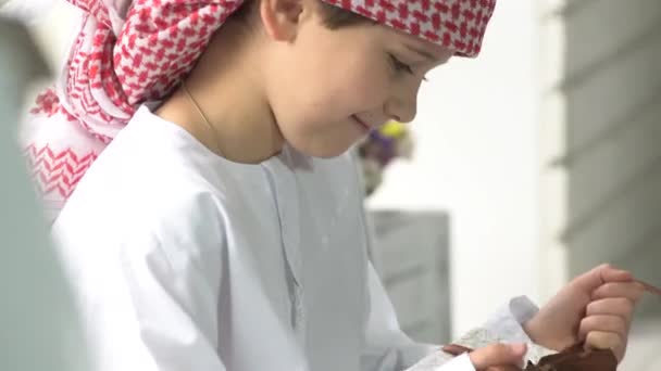 Kleine schattige Arabische jongen pakt het geschenk. — Stockvideo