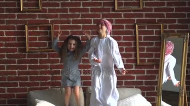İki Arap çocuklar kanepede kapalı atlamak.