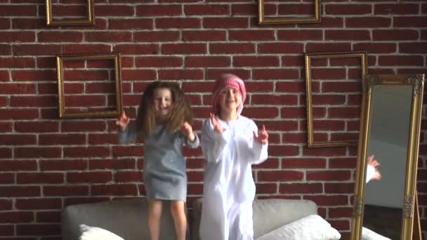 Two arabic kids jump on sofa indoor. — Stock Video