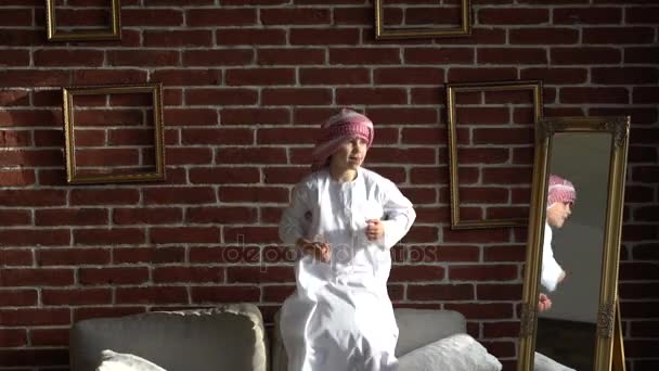 Счастливый арабский мальчик прыгает на диване . — стоковое видео