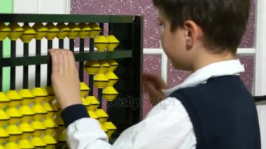 Okul çocuk abaküs tutan bir sınıfta öğretmen olarak giyinmiş.