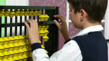 Okul çocuk abaküs tutan bir sınıfta öğretmen olarak giyinmiş.