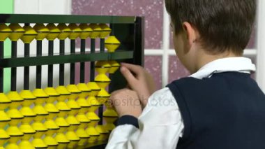 Okul çocuk abaküs tutan bir sınıfta öğretmen olarak giyinmiş.