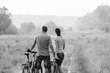 Bisiklet alanında genç çift. Siyah ve beyaz. Avrupa insan.