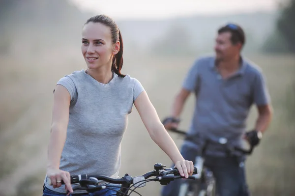 Happy young couple with bicycles in countryside. — Stock Photo, Image