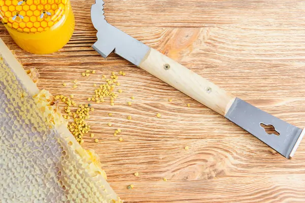 Miel fresca en el peine y las herramientas del apicultor sobre un fondo vudú. Plano y vista superior —  Fotos de Stock
