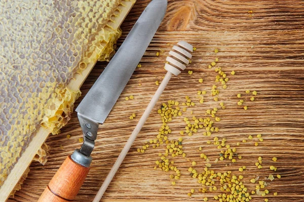 Свіжий мед у гребінці та інструменти бджоляра на хороброму головному тлі. Плоский простір і вид зверху — стокове фото