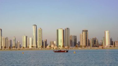 Sharjah, Birleşik Arap Emirlikleri - Şubat 10 2017:Small turist tekne rides yalnız Sharjah sahil şeridi günbatımı zamanı Şubat tarihinde 10,2017.
