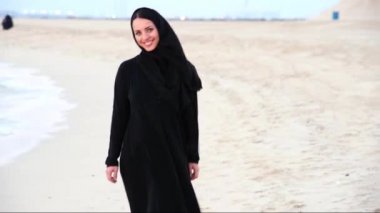 Sahilde abaya giyen bir kadın portresi. Orta Doğu.