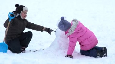 Çocuklar küçük bir kardan adam bina. Europe.