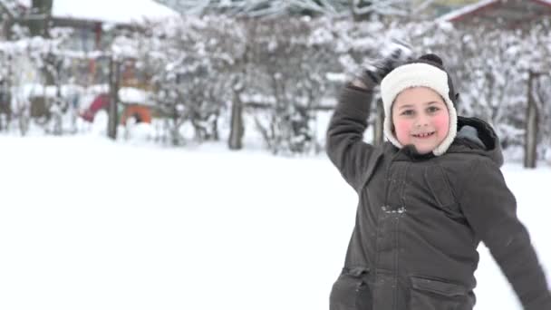 雪玉で美しい冬位に楽しんで暖かいコートの少年 — ストック動画