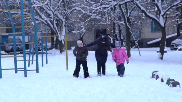 外の雪の吹きだまりで遊んで笑って Winterwear の幸せな子どもたち スローモーション — ストック動画
