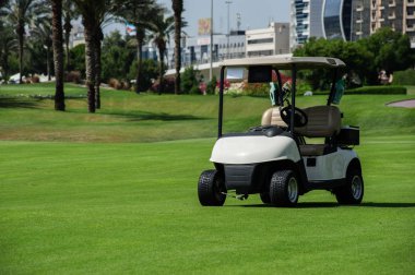 Yeşil golf sahasında beyaz golf arabaları..