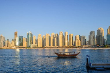 Jumeirah Plaj Konutu 'ndaki (Jbr) çeşitli gökdelenlerin önplanı olarak büyüleyici turkuaz suları görülüyor.