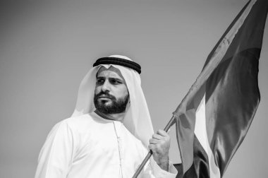 Gururlu Arap Emirlikleri adam çölde bir Birleşik Arap Emirlikleri bayrağı tutarak.