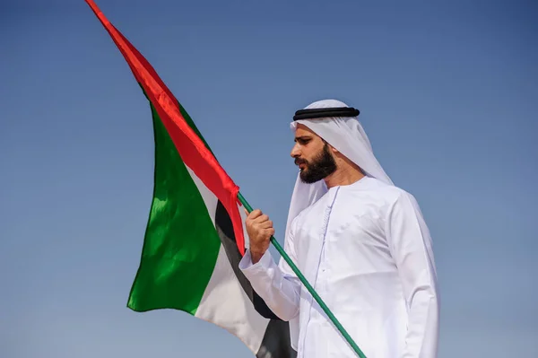 Stolzer arabischer Emirat-Mann mit einer Uae-Fahne in der Wüste. — Stockfoto