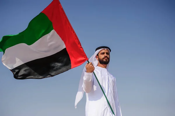 Stolt arabian Emirati man innehar en Uae flagga i öknen. — Stockfoto