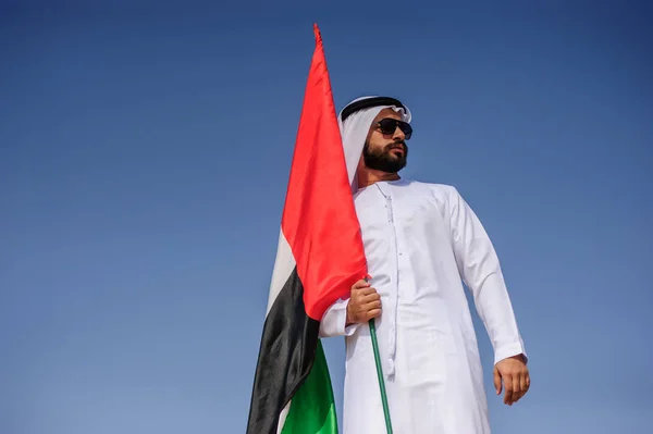 Υπερήφανος άνθρωπος αραβικό Εμιράτα, κρατώντας μια σημαία των ΗΑΕ στην έρημο. — Φωτογραφία Αρχείου