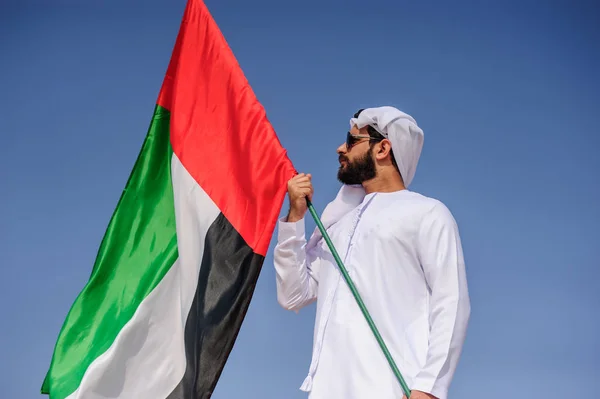 Stolt arabian Emirati man innehar en Uae flagga i öknen. — Stockfoto