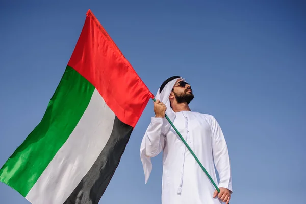 Stolt arabian Emirati man innehar en Uae flagga i öknen. — Stockfoto