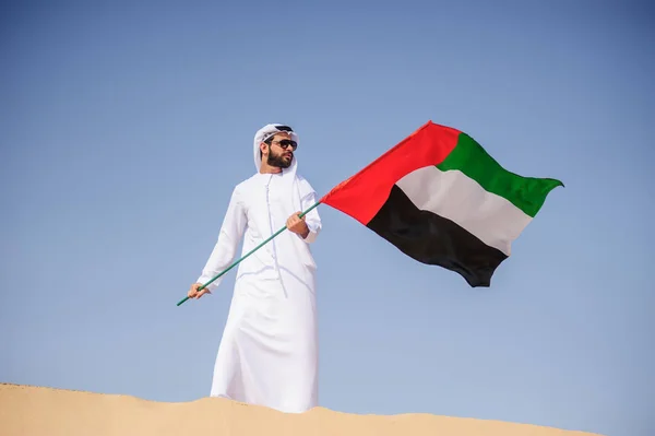 Fier homme émirati arabe tenant un drapeau des EAU dans le désert . — Photo