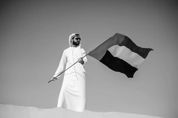 Orgulloso hombre árabe emiratí sosteniendo una bandera de los EAU en el desierto . — Foto de Stock