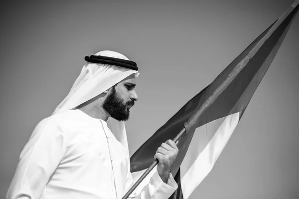 Orgulhoso homem Emirado árabe segurando uma bandeira dos Emirados Árabes Unidos no deserto . — Fotografia de Stock