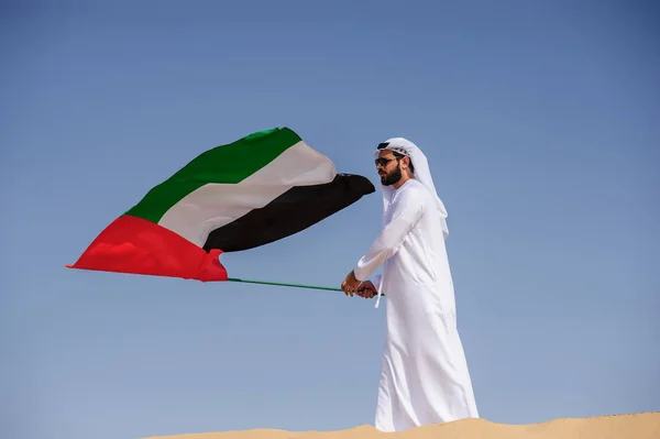 사막에서 Uae 국기를 들고 자랑 아라비아 Emirati 남자. — 스톡 사진