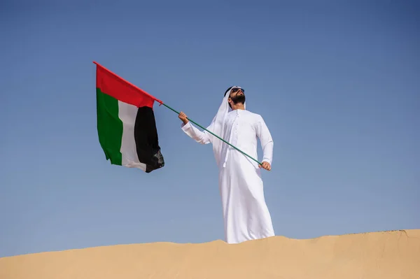Stolzer arabischer Emirat-Mann mit einer Uae-Fahne in der Wüste. — Stockfoto