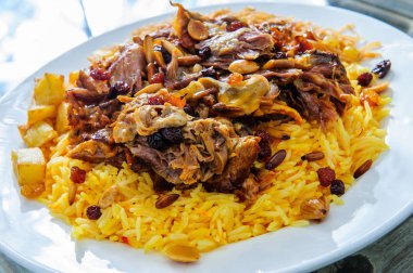 Koyun eti ve patatesle kaplı sarı pirinç tabağı..