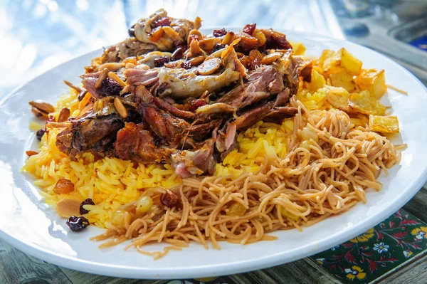 Plaat van gele rijst gegarneerd met schapenvlees en aardappelen. — Stockfoto