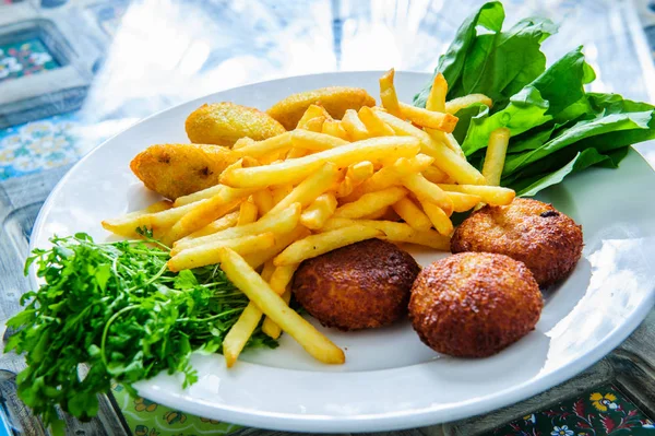 Serving of falafel and chips served on a black plate with sauce. — 스톡 사진