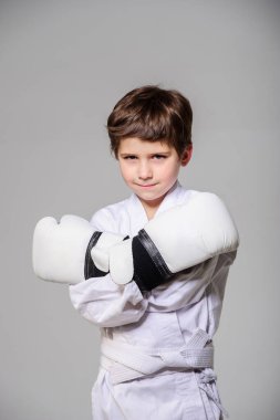 Boks eldivenli çocuk içeride poz veriyor..