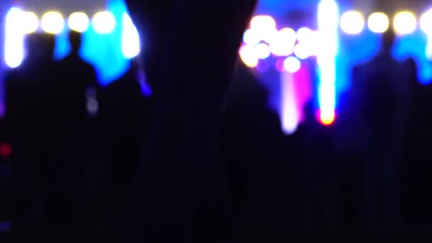 Persone offuscate che vanno allo spettacolo notturno. Illuminazione scenica brillante. 4K sfondo bokeh colpo — Video Stock