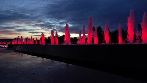 Moderna röd fast sken park fontäner mot sena solnedgången himmel. Arkitektoniska Led-belysning. Super slow motion sköt — Stockvideo