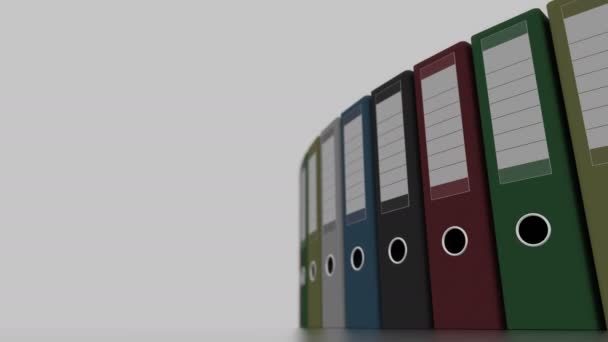 Rotating colored office binders for reports and presentations. 4K seamless loopable clip, shallow focus — Stock Video