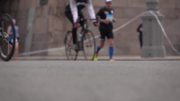 Piloto de cadeira de rodas desfocado, corredores e ciclistas. Igualdade de oportunidades e conceito de concorrência. câmera lenta fundo bokeh tiro — Vídeo de Stock