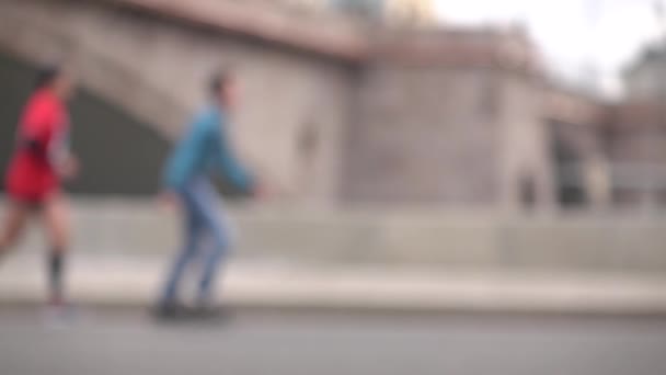 Defocused runners and people on roller skates. Advantage concept. Super slow motion background bokeh shot — Stock Video