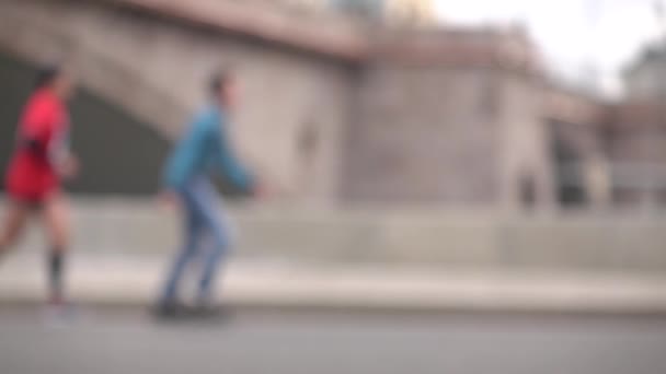 Defocused biegaczy i ludzi na rolkach. Koncepcja Advantage. Super Slow Motion tła bokeh strzał — Wideo stockowe