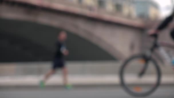 Tanınmaz defodaklı bisikletçiler ve koşucular. Aktivite kavramı. Yavaş hareket arka plan bokeh atış — Stok video