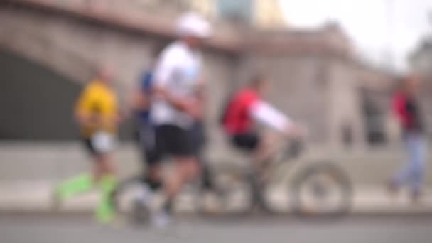 Niewyraźne rowerzystów i biegaczy. Koncepcja działania. Super powolny ruch tło bokeh wideo — Wideo stockowe