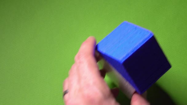 Geschäftsmann platziert Spielzeughaus mit blauem Dach und kleinem Schlüssel auf grünem Hintergrund. Immobilienmarktkonzept. 4k-Schuss — Stockvideo
