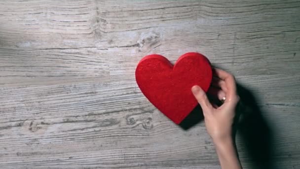 Chica colocando dos corazones rojos en una mesa de madera, vista superior. Romance, amor, San Valentín, conceptos de relación. Vídeo 4K — Vídeo de stock