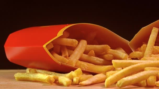 Fast-Food-Kartons mit Pommes frites. frittierte Kartoffeln 4k Nahaufnahme Dolly Schuss vor schwarzem Hintergrund — Stockvideo